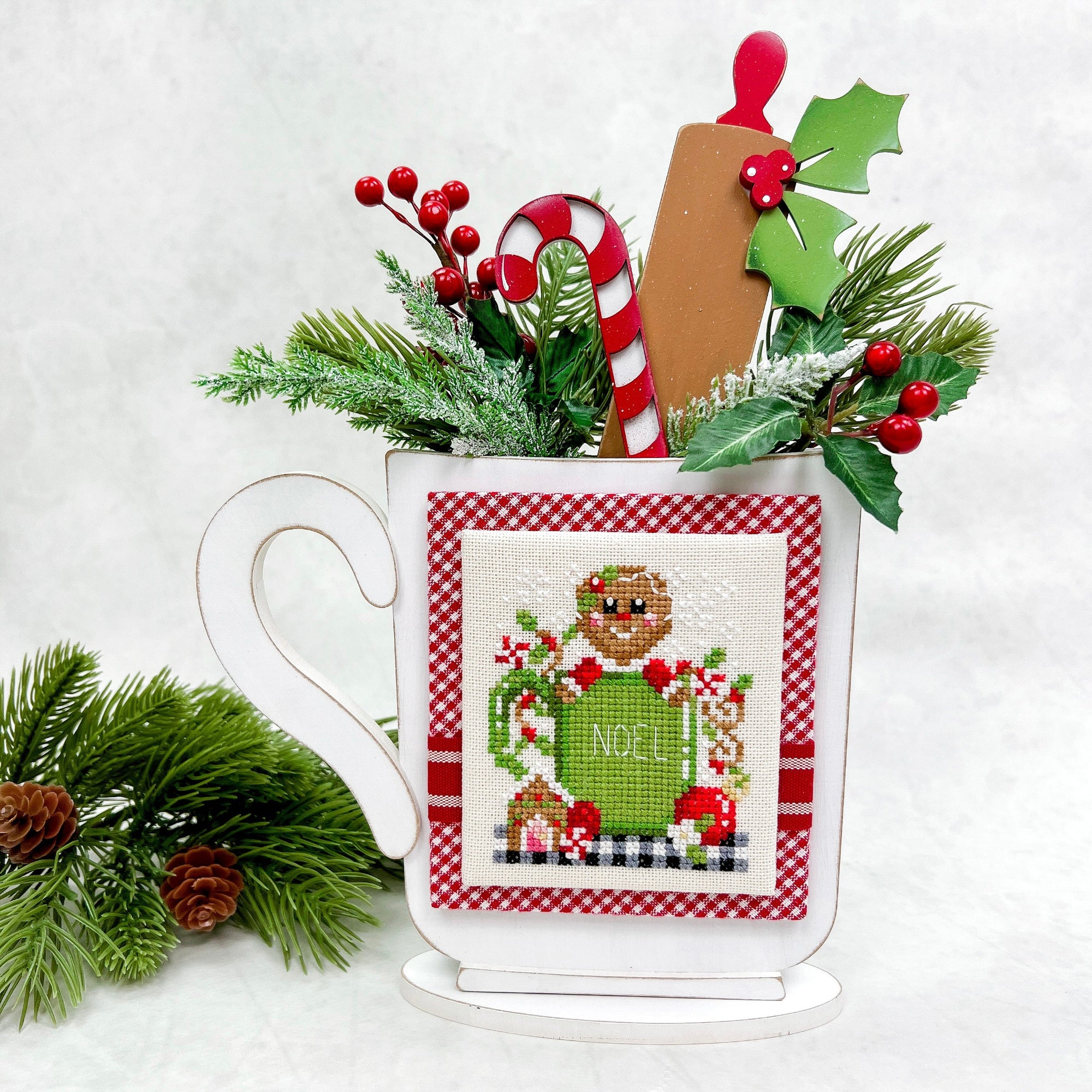 Christmas mug cross stitch display backer with candy cane, rolling pin, and holly leaf. 