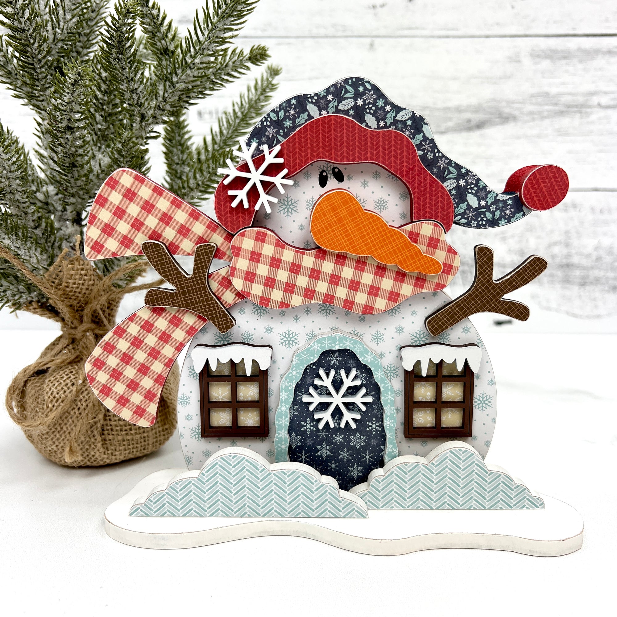 Snowman house wood decoration with red scarf and carrot nose.