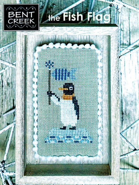 Cross-stitched penguin holding a fish flag with Bent Creek branding.