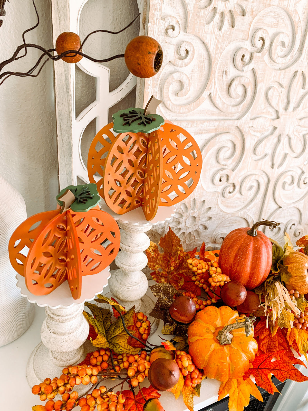 3D wood pumpkins craft kit, 3D pumpkins for fall decorations for a shelf or mantle. Dimensional pumkins shown on candlesticks on a fireplace.