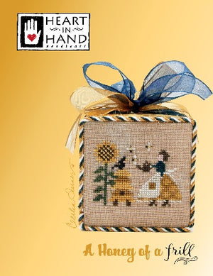 Cross-stitched box with a bee and sunflower design on a yellow background, featuring 'Heart in Hand' branding.
