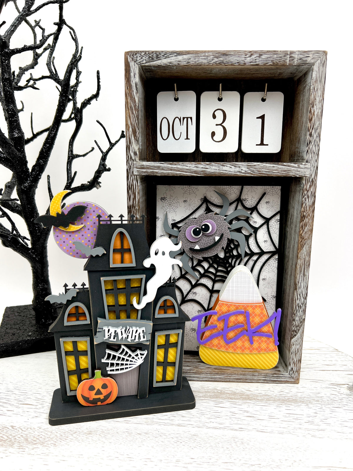 spider, spider web. candy corn, and haunted house shown with a seasonal calendar box