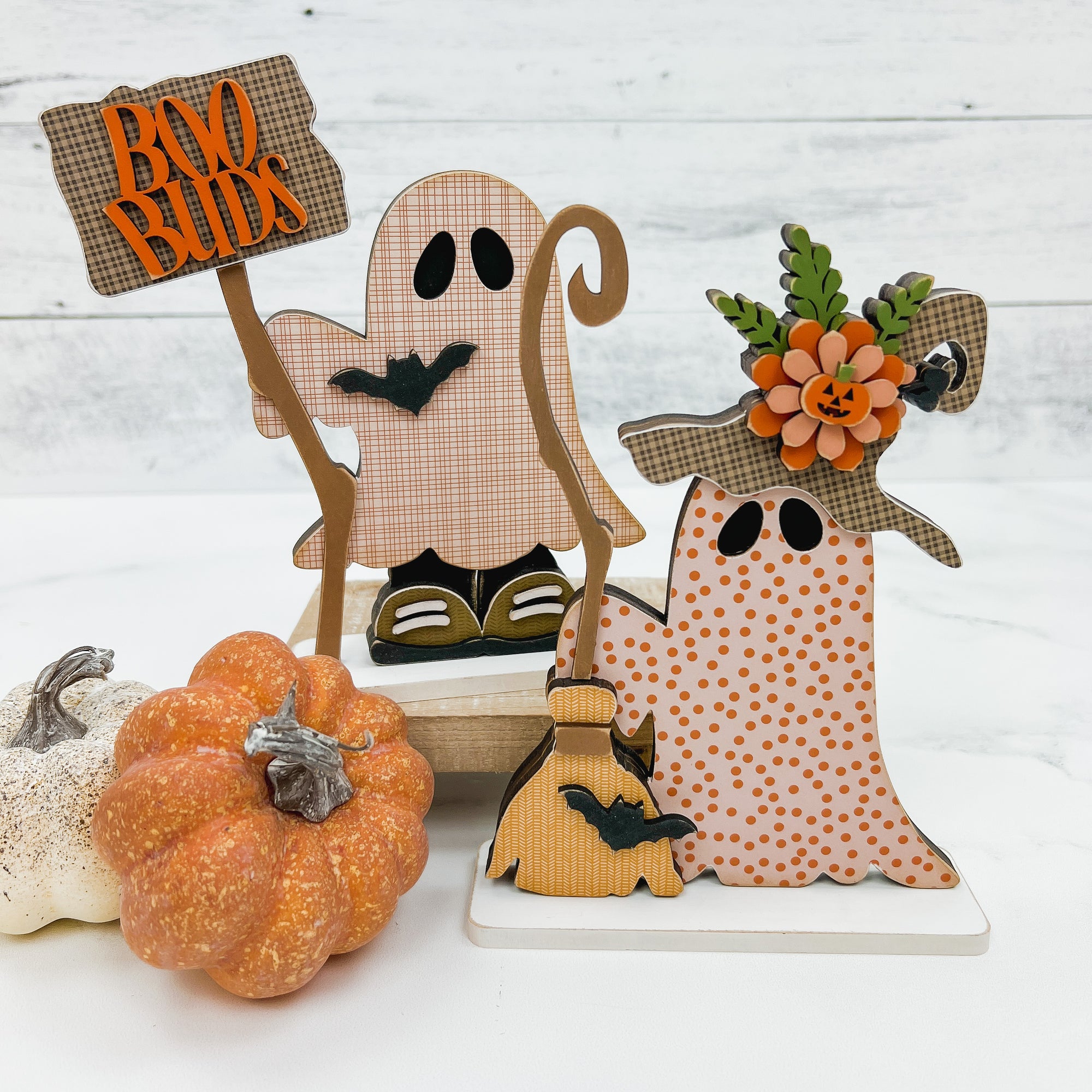 Two cute ghosts holding a sign and broom. She has a witches hat and he is holding a signthat says boo buds. Wood decor DIY craft kit.