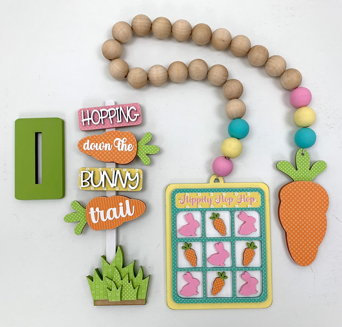 Easter wood sign that says hopping down the bunny trail and a wood beaded tic tac toe and carrot garland.