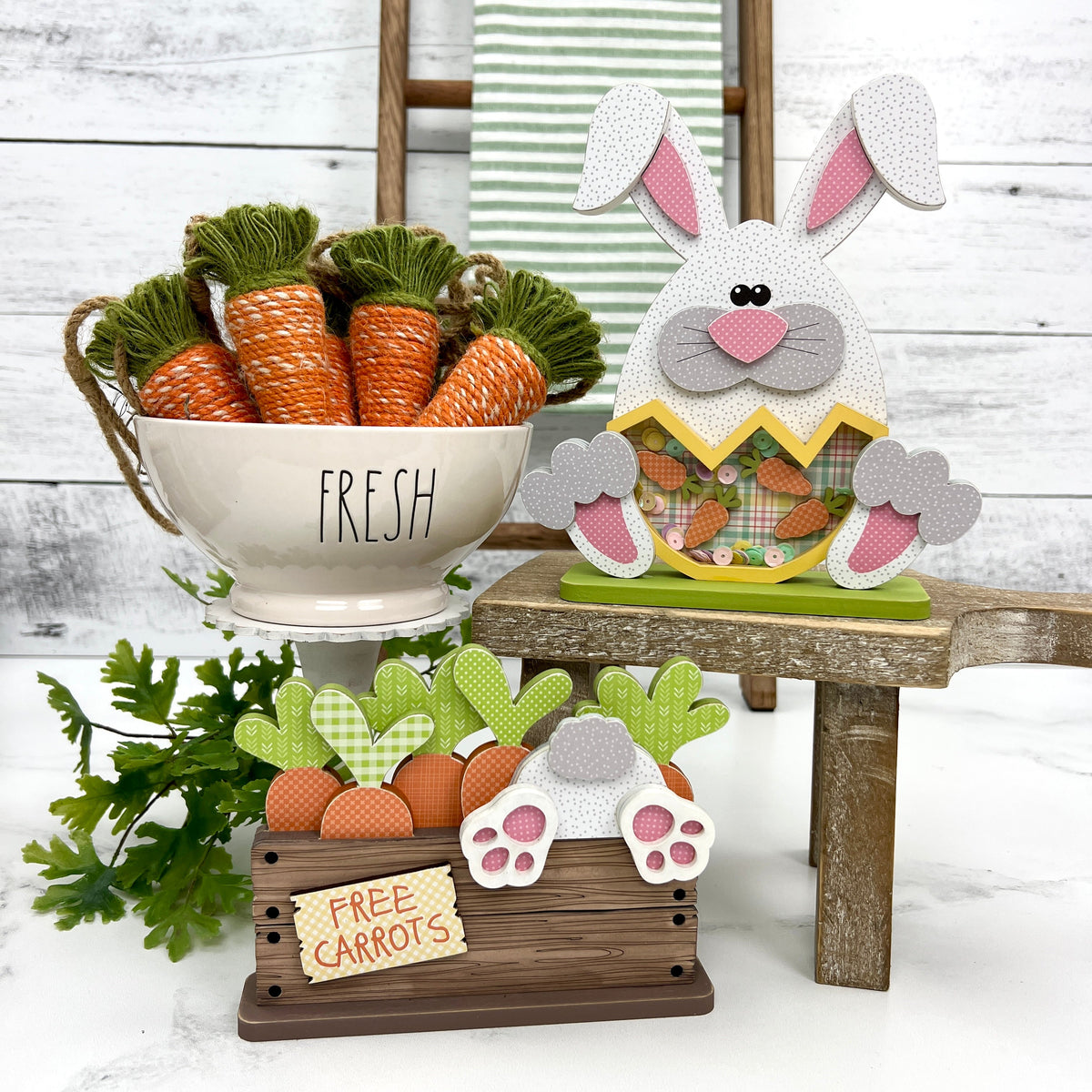 Easter bunny holding a cracked egg and a wood crate with a bunny butt and carrots wood decorations
