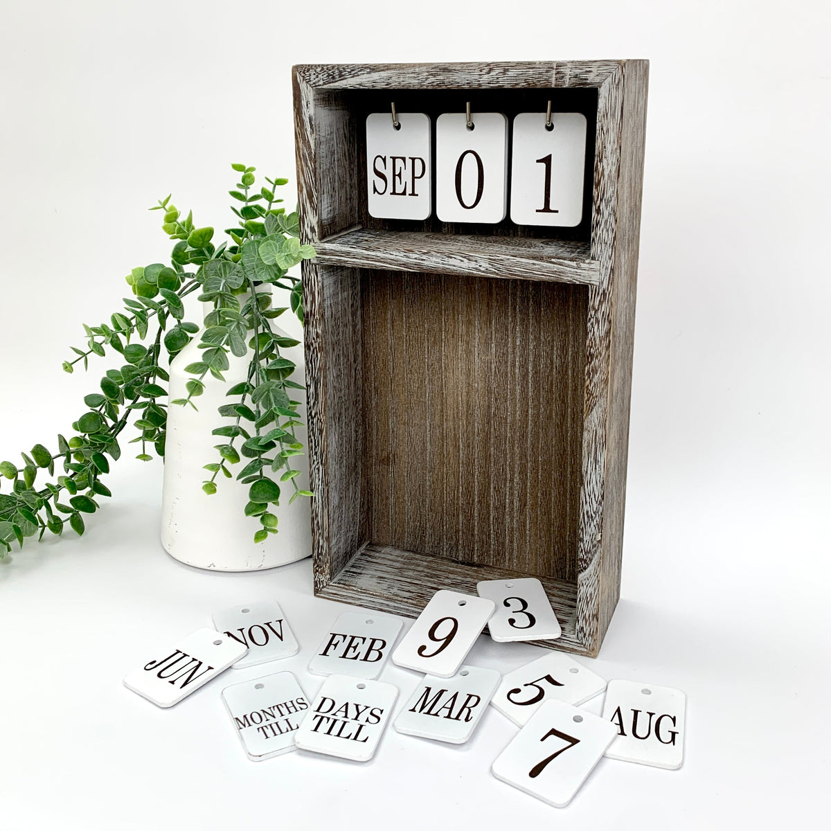 Changing Seasonal calendar box with month and number tiles.