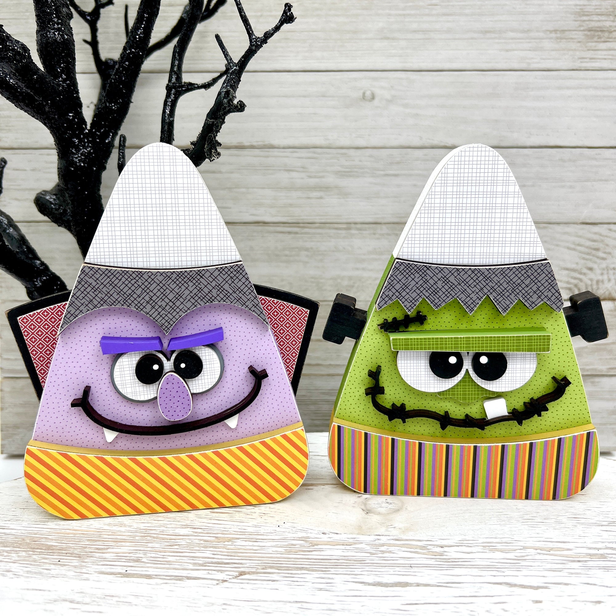 Candy corn shaped wood decorations designed to look like Frankenstein and Dracula.