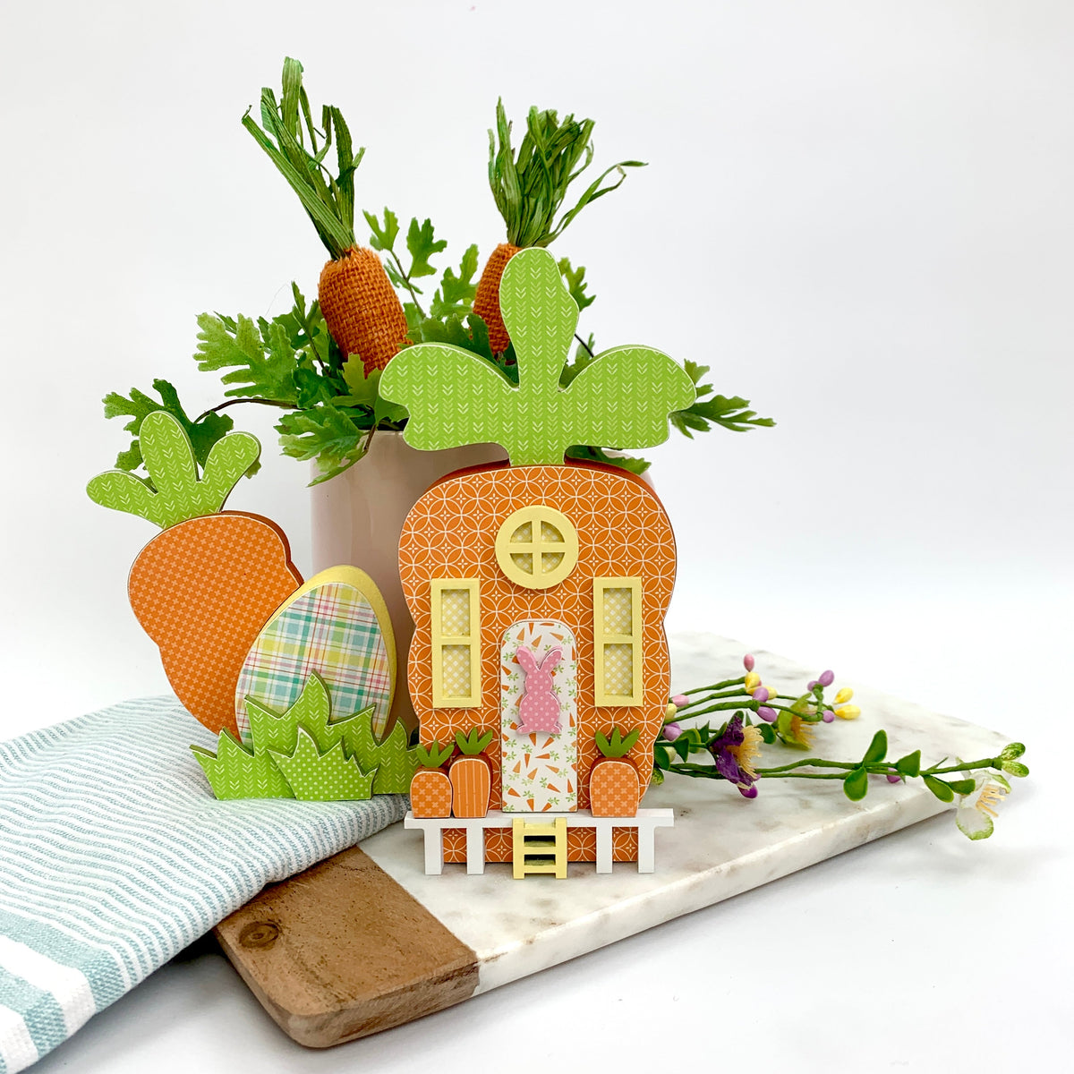 Wood carrot hut decoration with small carrot and egg on a tray