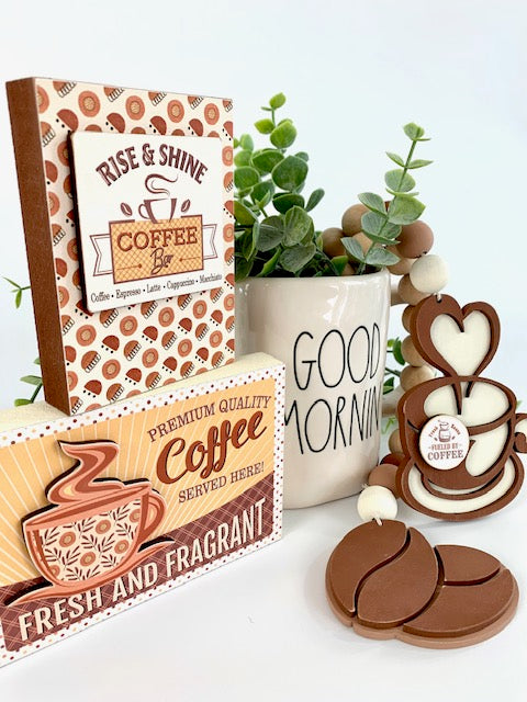 Coffee themed wood beaded garland with coffee beans and coffee cup. Two wood coffee signs for decorating trays, coffee bars, and coffee themed tiered trays. Side view
