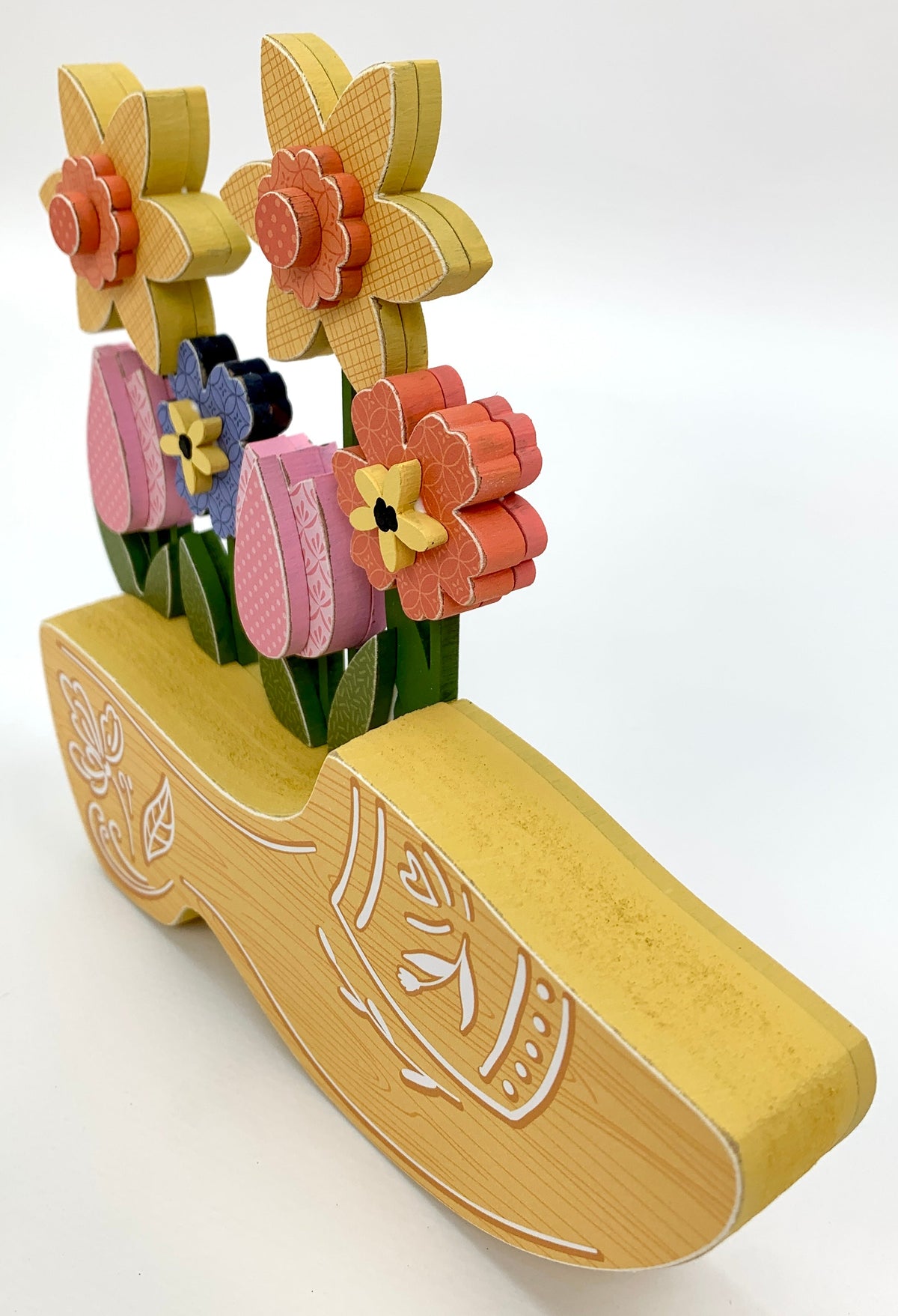 Yellow dutch clog wood decoration with spring flowers side view