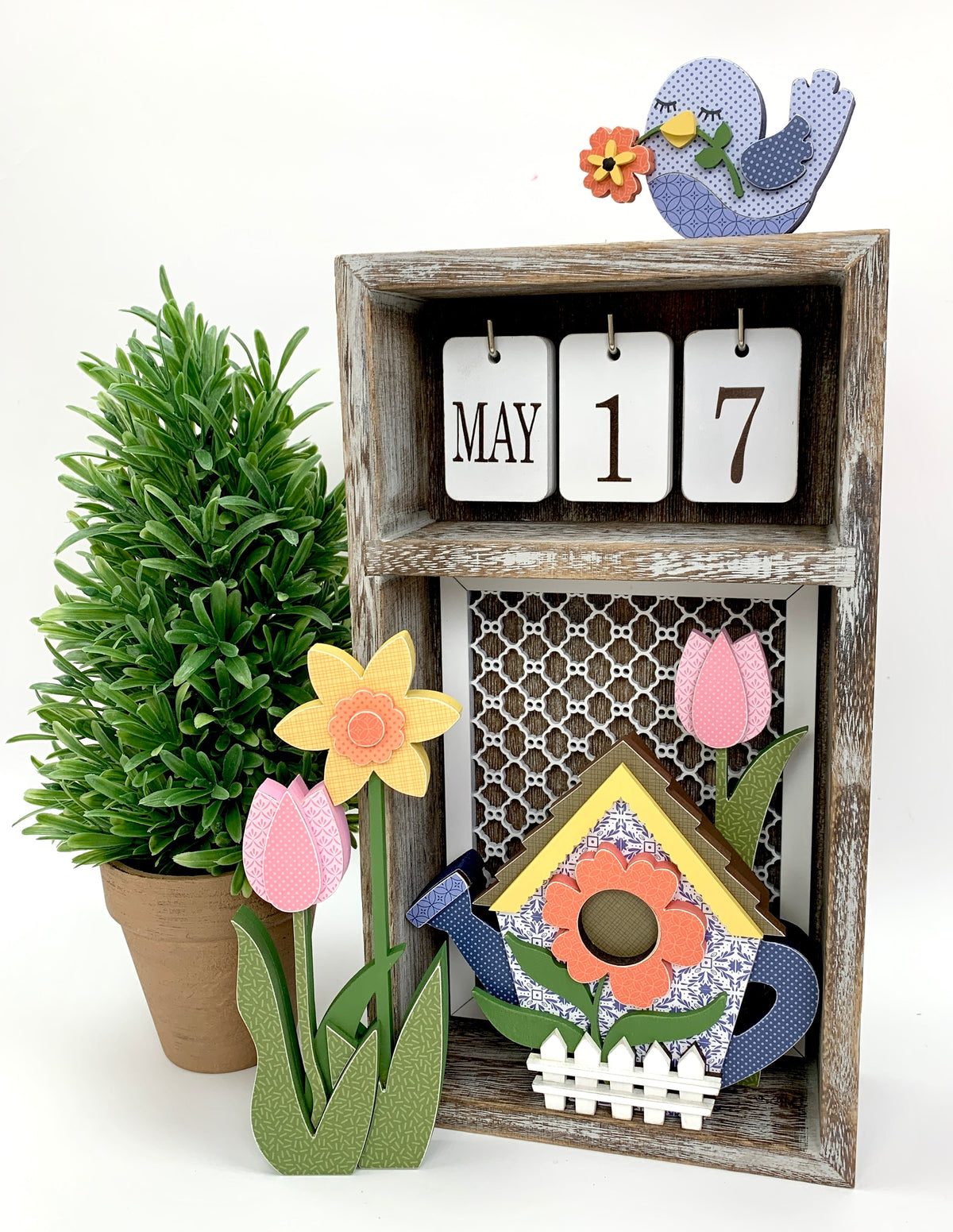 changing seasonal calendar box with spring flowers, watering can birdhouse, tulips and daffodils
