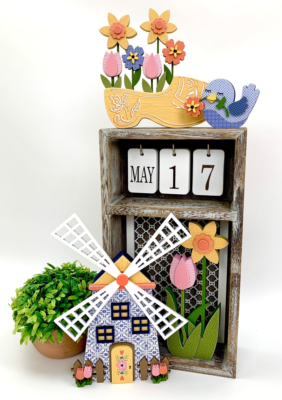 Changing seasonal calendar box with dutch windmill, yellow clog with spring flowers, and blue bird