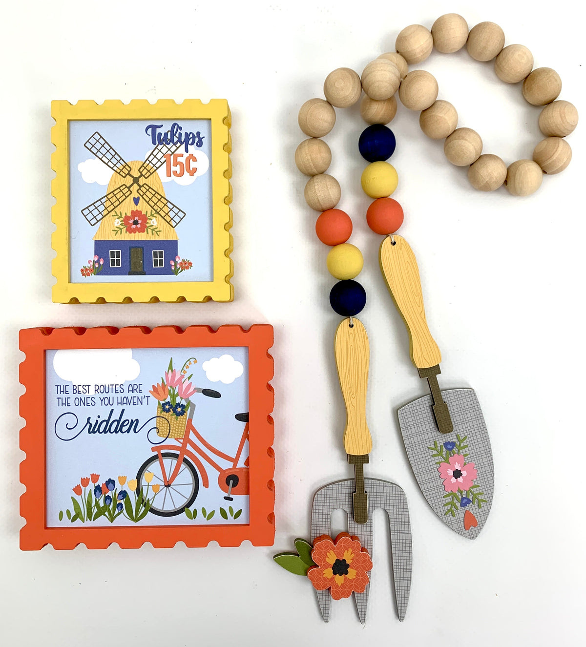Spring teired tray  block signs with windmill, bicycle, and a beaded garland with gardening tools.
