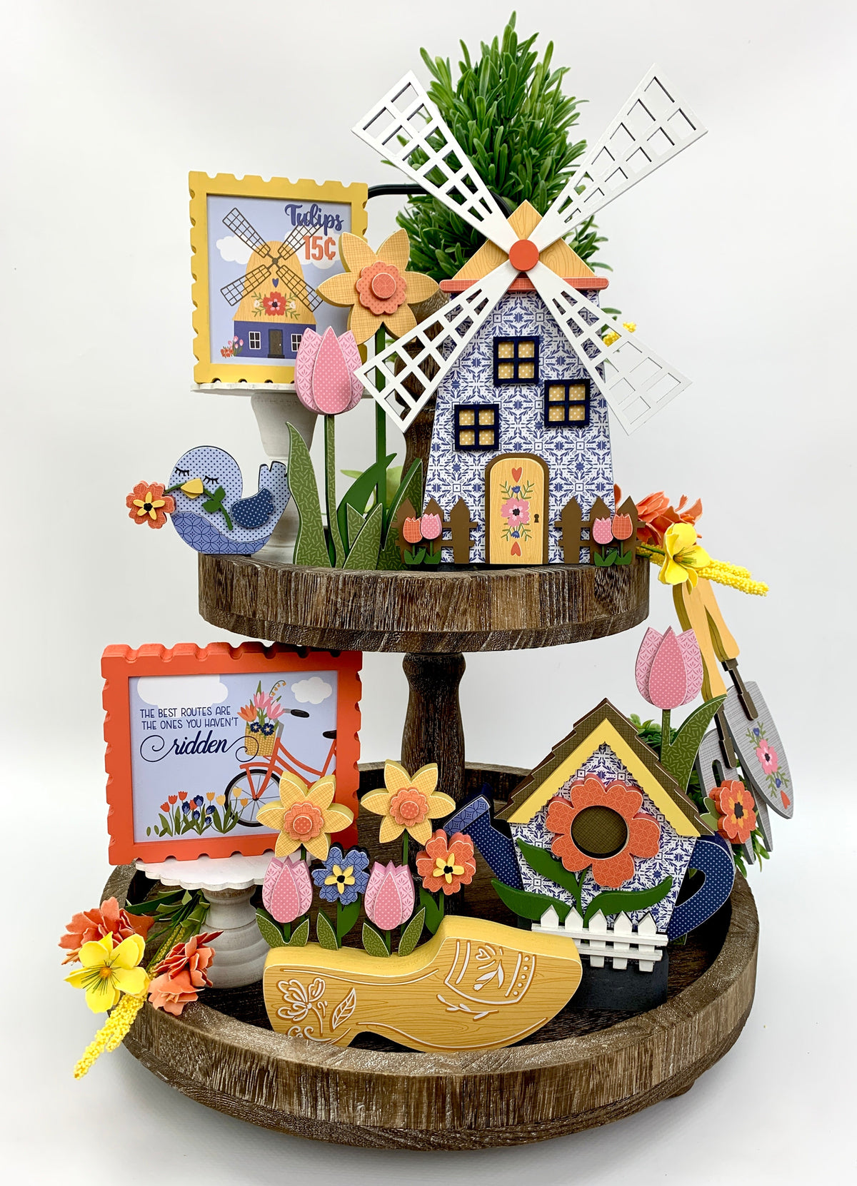 Tiered tray wood decorations with Dutch spring theme. Windmill, yellow clog, water can birdhouse, and gardening tools