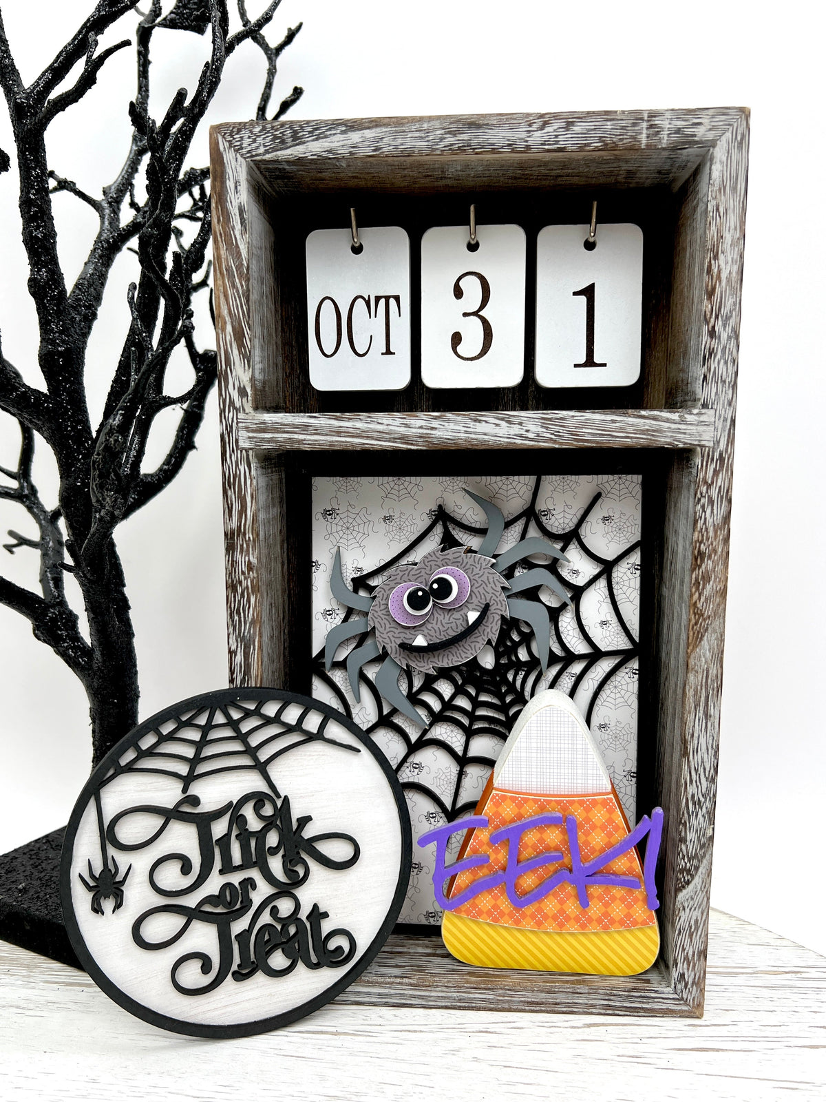 Halloween wood decorations with a trick or treat sign, candy corn spider and web