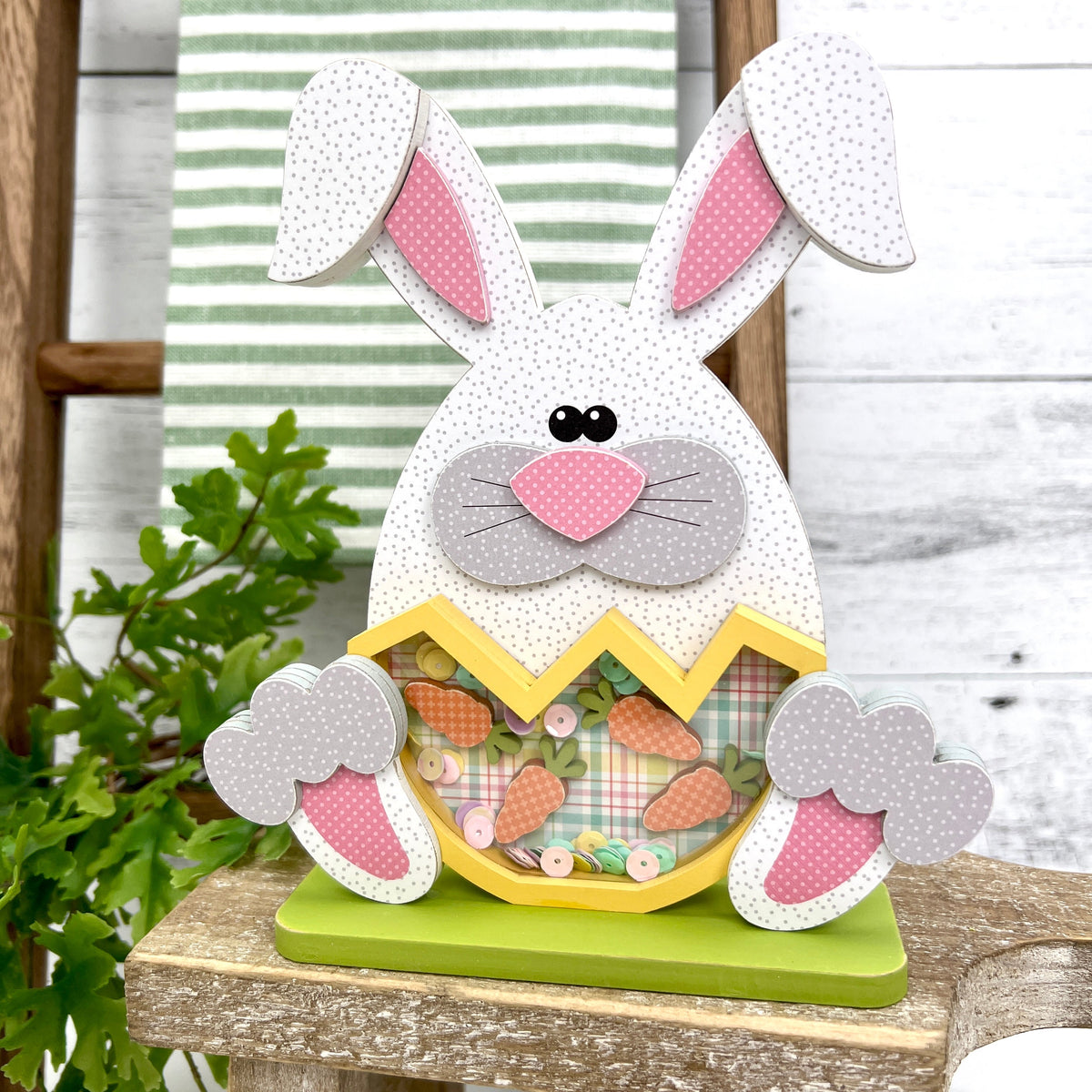 Bunny holding cracked egg with carrots inside