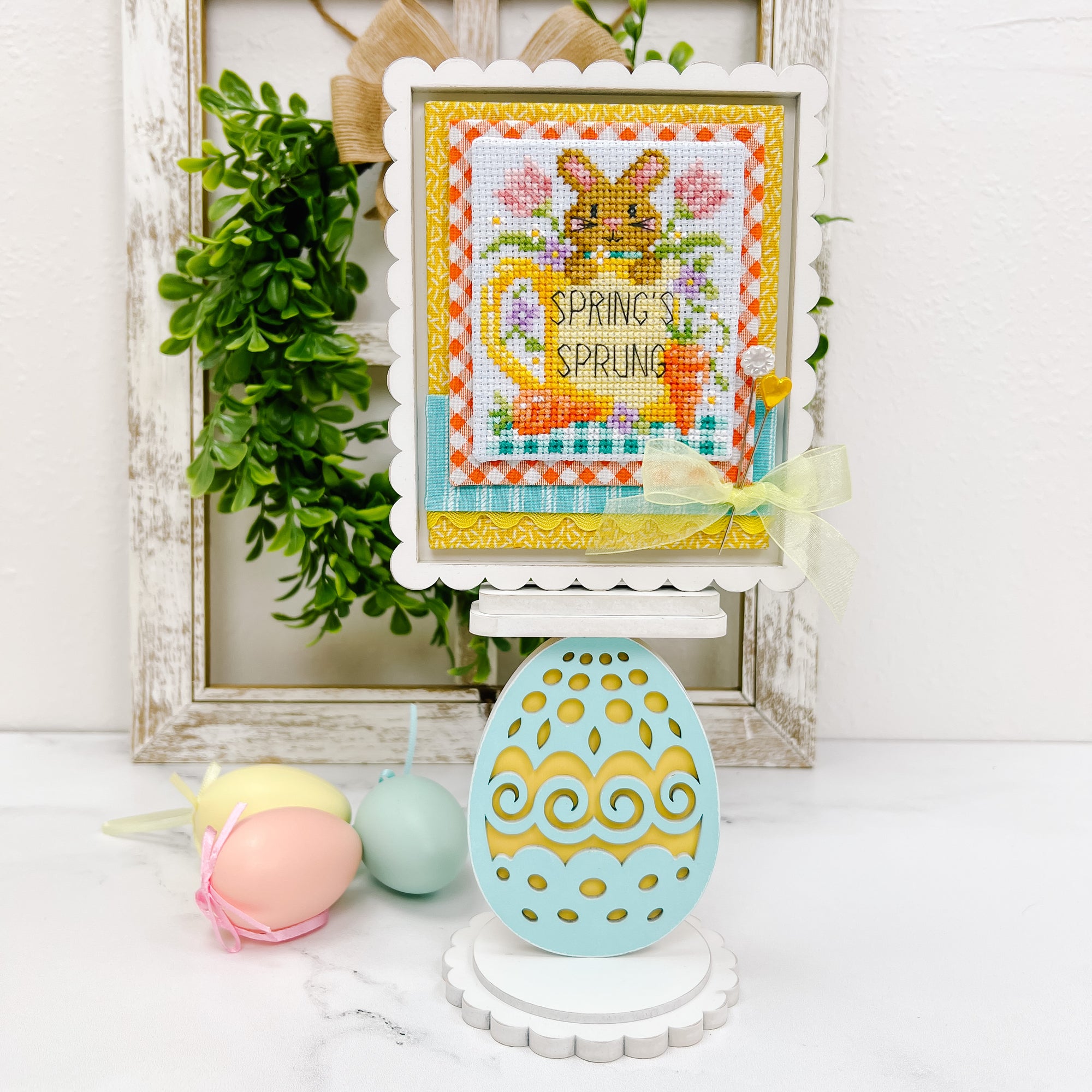 Egg shaped pedestal cross stitch display with a finished cross stitch by Shannon Christine Designs