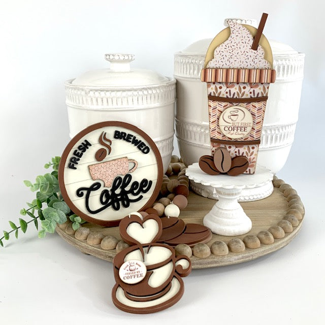 Coffee latte cup wood decoration, coffee shiplap sign, and coffee bean wood beaded garland shown on wood tray for coffee bar decorating. 