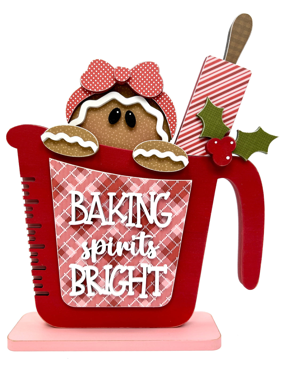 Christmas wood decor craft kit that is a red measuring cup with a gingerbread girl and candy cane rolling pin inside.