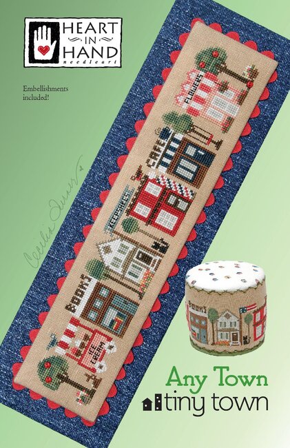 Cross-stitched pattern of a town scene with a ice cream cart, bookstore, cafe and flower shop