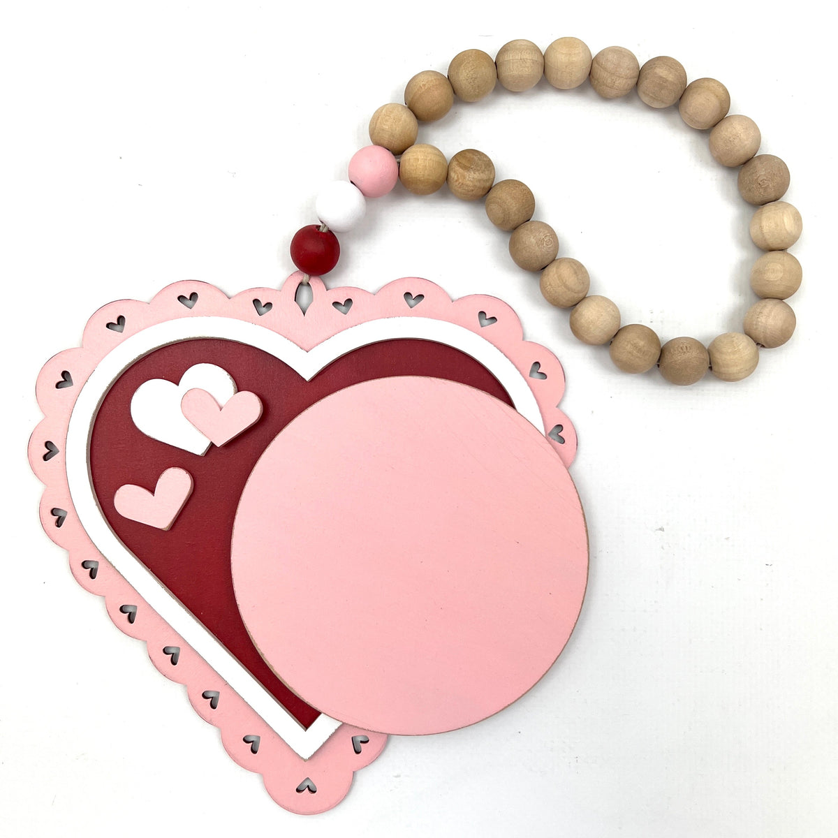 Red, pink, and white beaded heart hanging garland for cross stitch display backer.