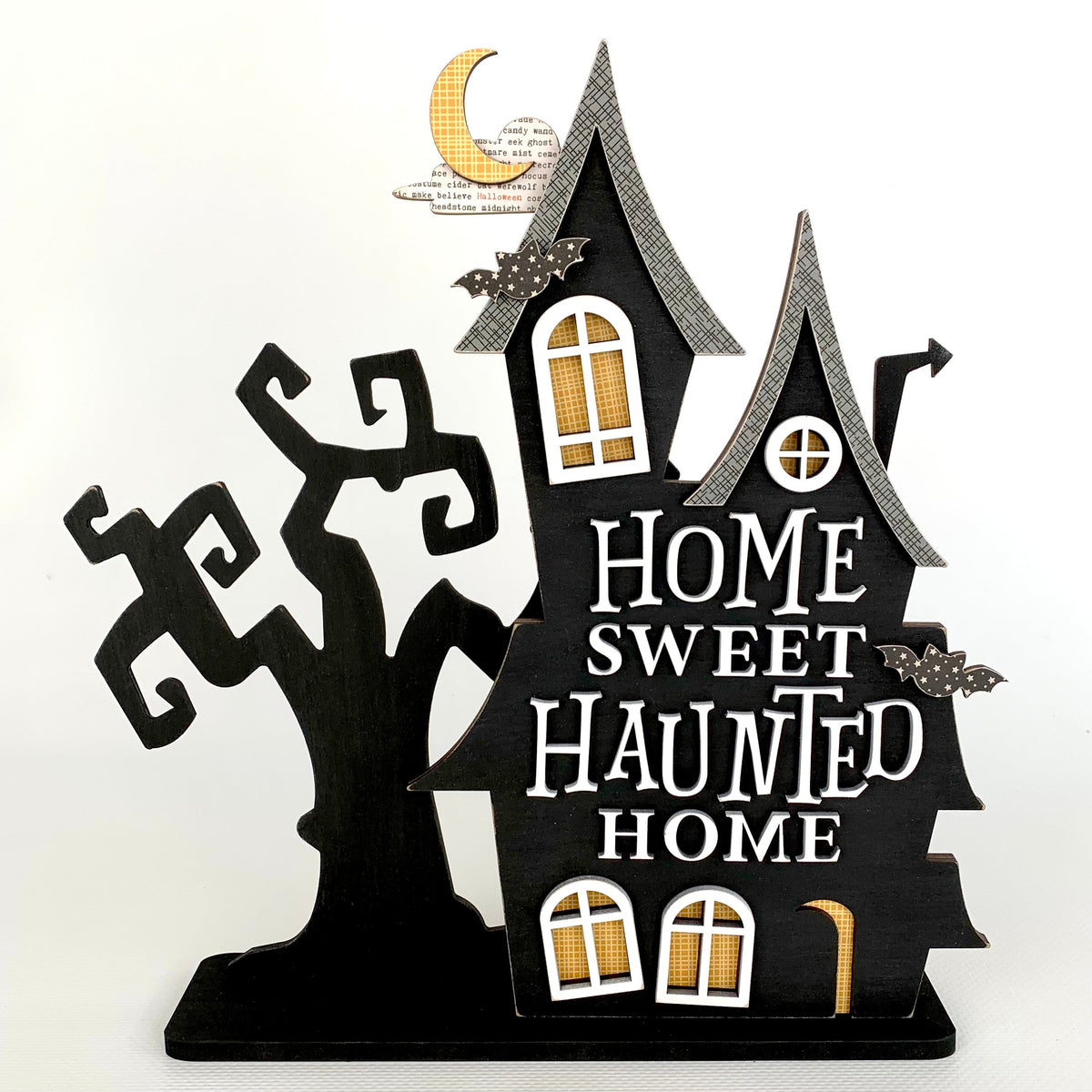 Halloween black and white wood haunted house with a Home sweet haunted home phrase, windows, bats, and a spooky tree.  Haunted house for Halloween home decor.  Halloween wood craft kit.
