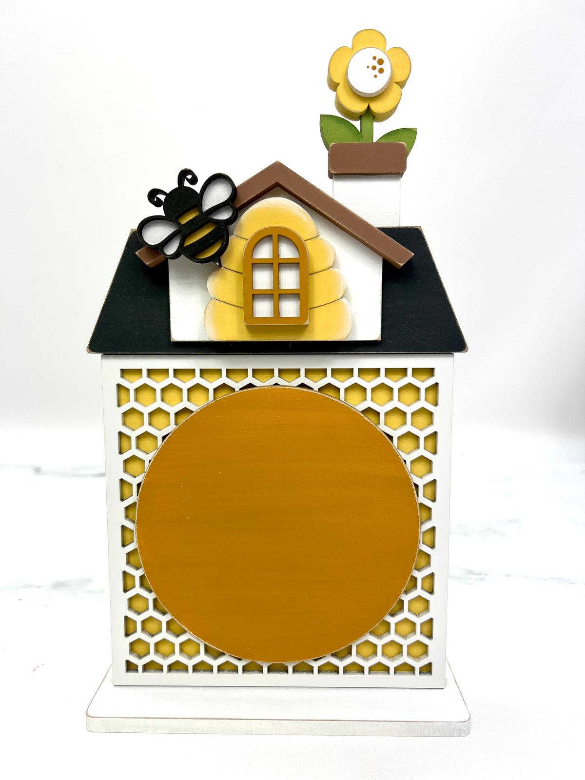 Honey bee themed house with honeycomb backing, bee hive window, and a blooming flower in the chimney for displaying a finished cross stitch piece