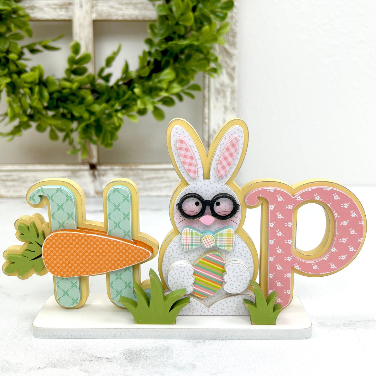Wood bunny and carrot easter decor that spells the word HOP in spring colors