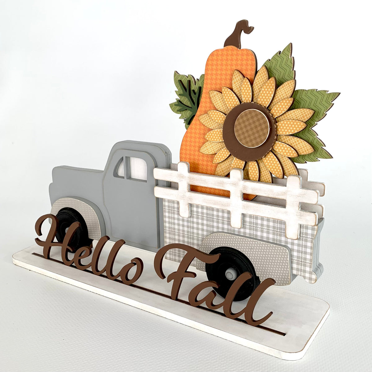 Interchangeable pick up truck with removable inserts to change monthly or seasonally.  Truck shown with a fall sunflower and orange pumpkin. This is a wood decor craft kit.
