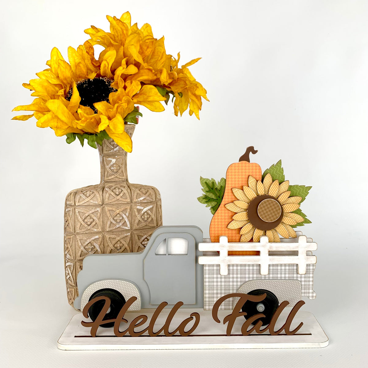 Interchangeable pick up truck with removable inserts to change monthly or seasonally.  Truck shown with a fall sunflower and orange pumpkin. This is a wood decor craft kit.