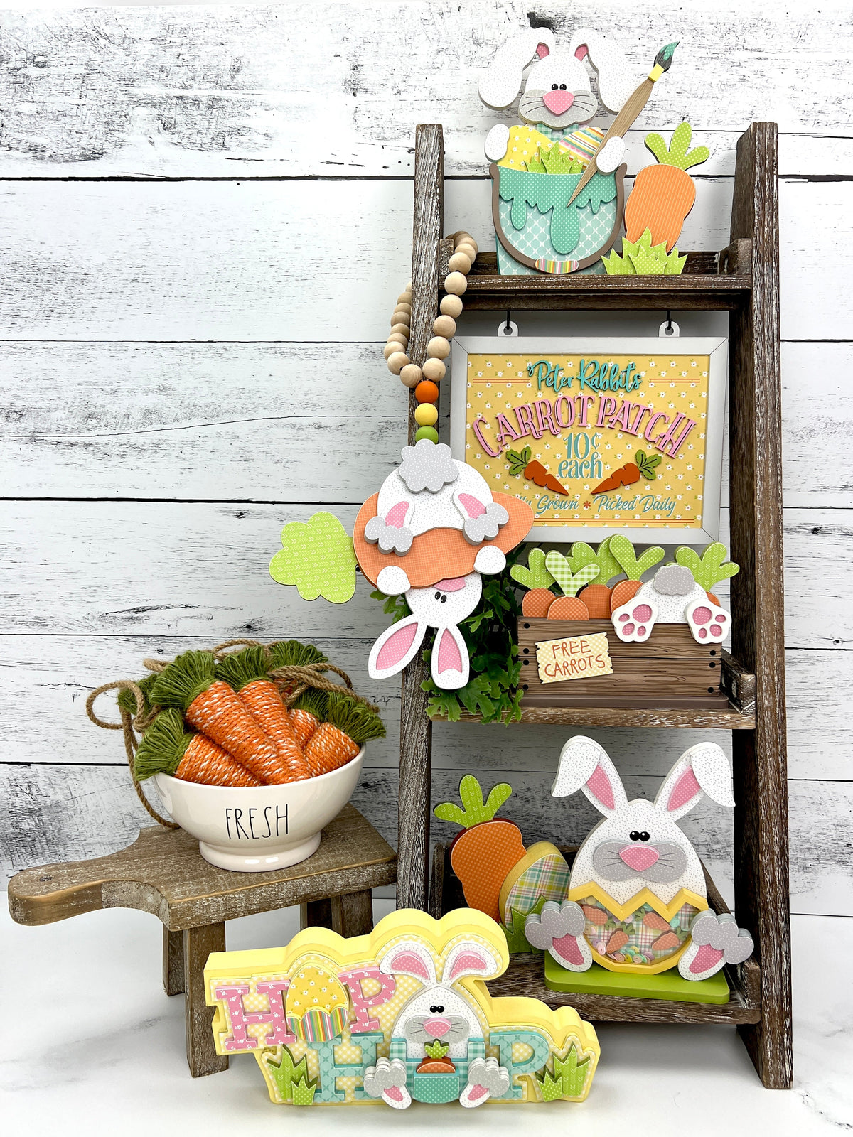 wood easter decorations shown on a leaning ladder shelf with bunnies and carrots