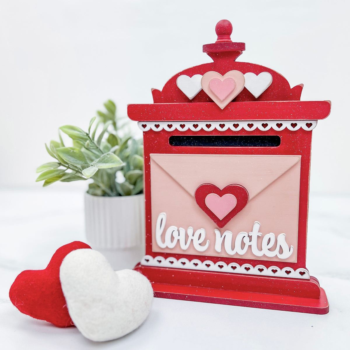 Red vintage mailbox decoration made of wood with an envelope on the front and a title that says, love notes.