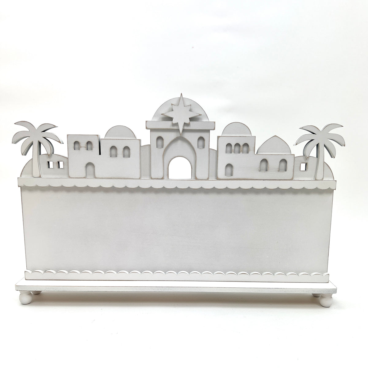 DIY Bethlehem nativity skyline wood display backer for cross stitch projects, with layered rooftops, arched windows, palm trees, and Star of Bethlehem.