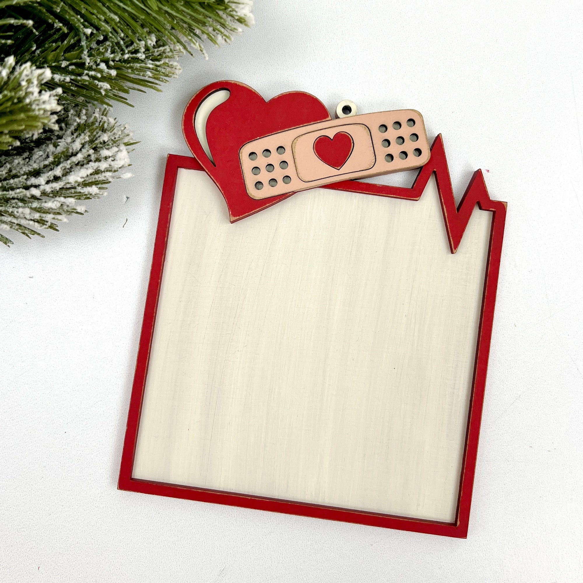 Decorative wooden frame with heart and bandage design on a white background