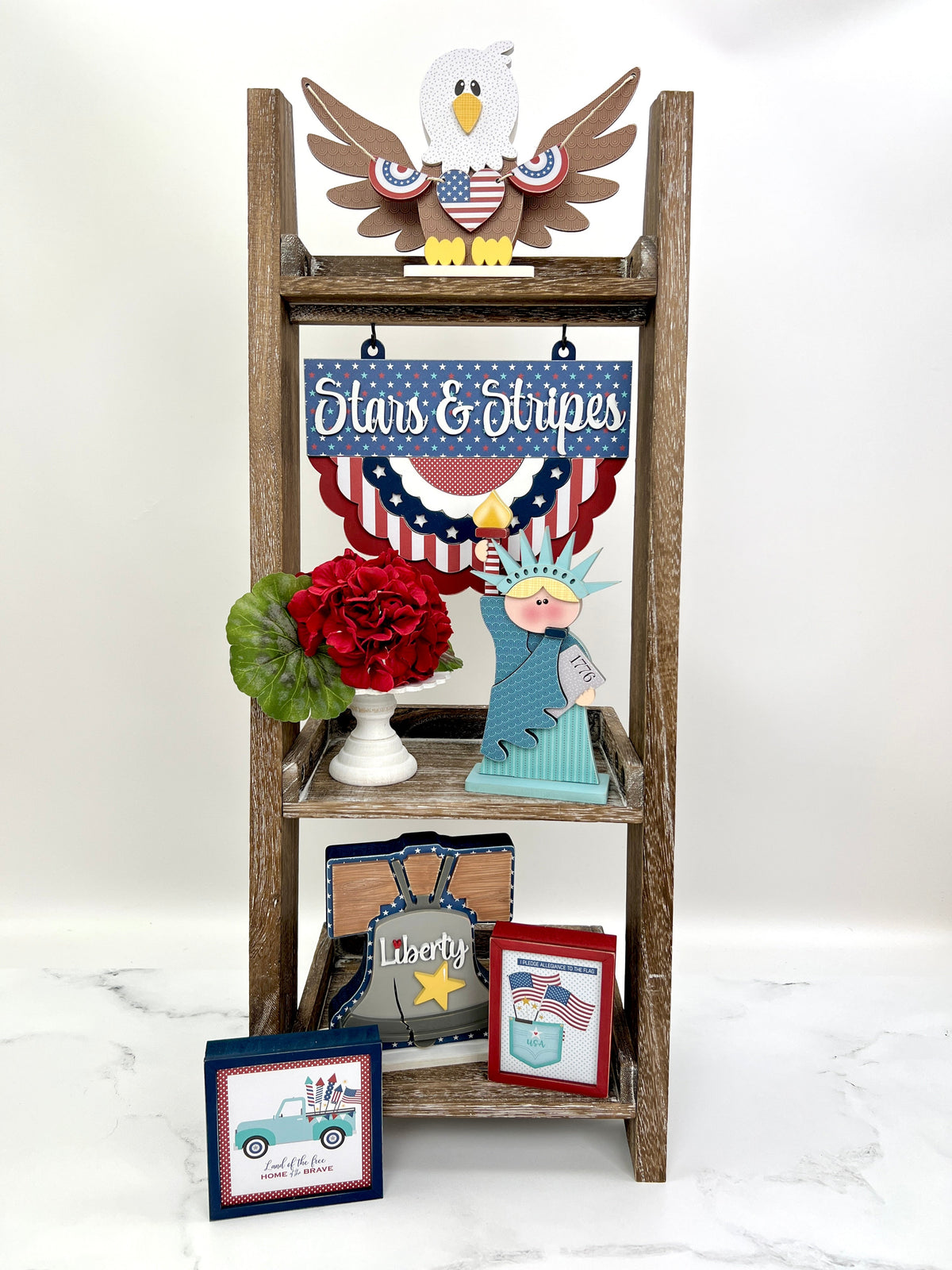 Patriotic and 4th of july wood decorations shown on a leaning ladder shelf