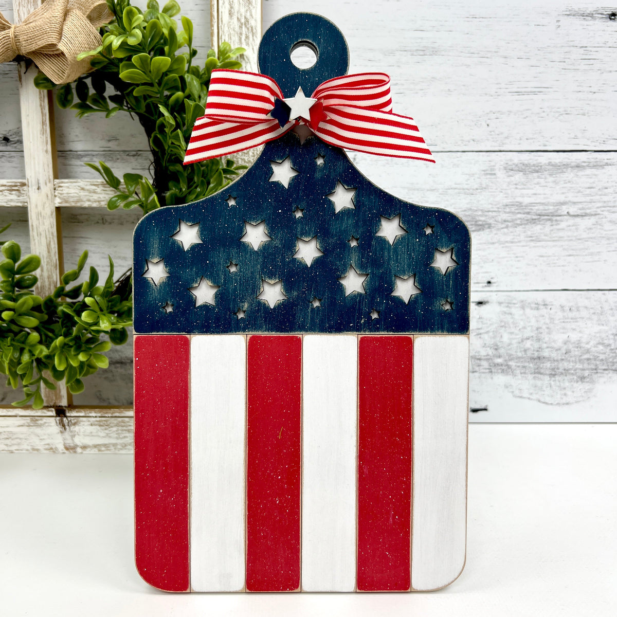 Patriotic themed wood cross stitch display backer painted red, white, and blue. Resembles an American flag flag.
