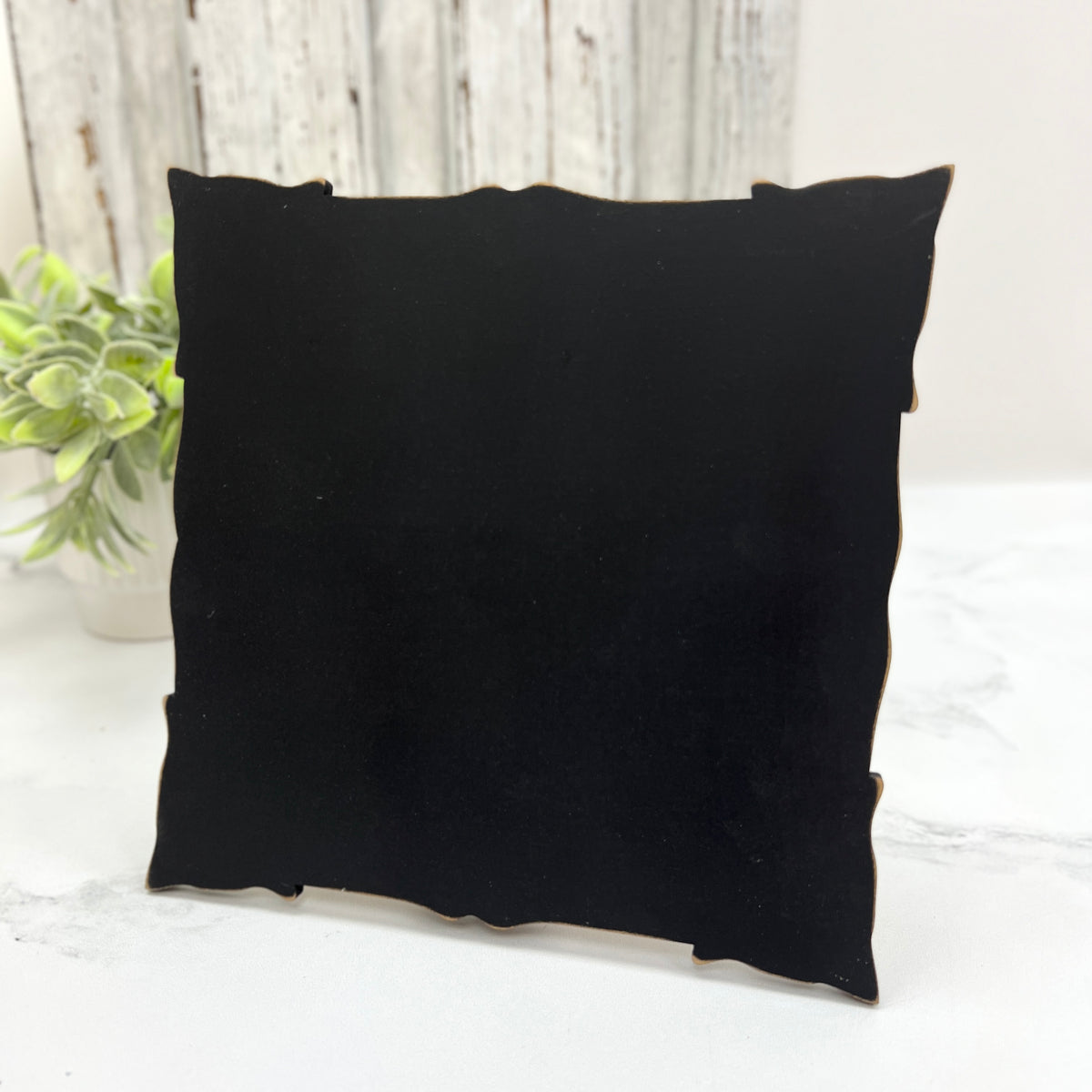 Back of pre-painted black cross stitch display with easel stand