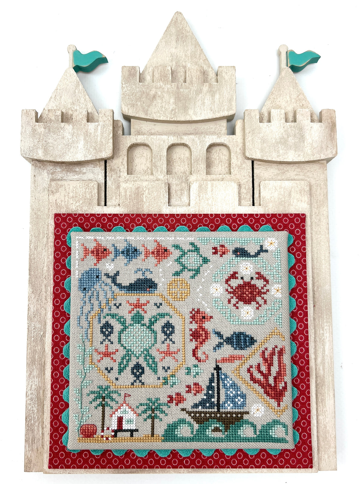Coastal unfinished wood cross stitch frame shaped like a sand castle for summer and ocean-themed stitched pieces