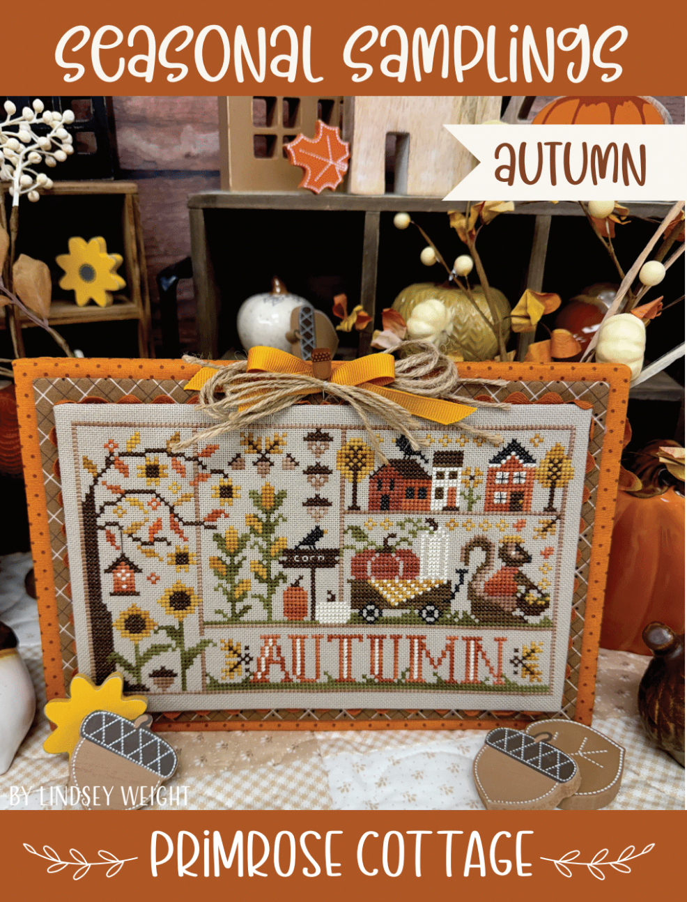 Autumn-themed cross-stitch sampler pattern with sunflowers, corn, squirrel, New England style clapboard houses