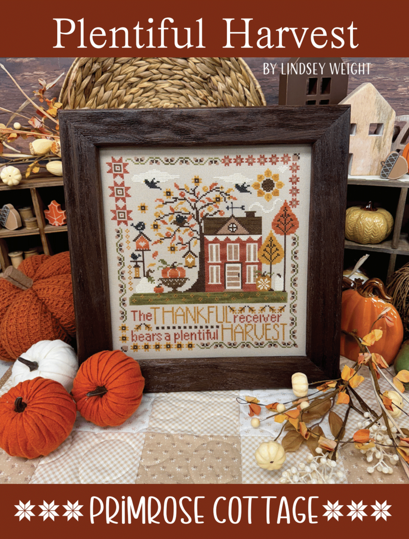 Framed cross-stitch pattern with autumn theme and 'Plentiful Harvest' text, surrounded by pumpkins and foliage.