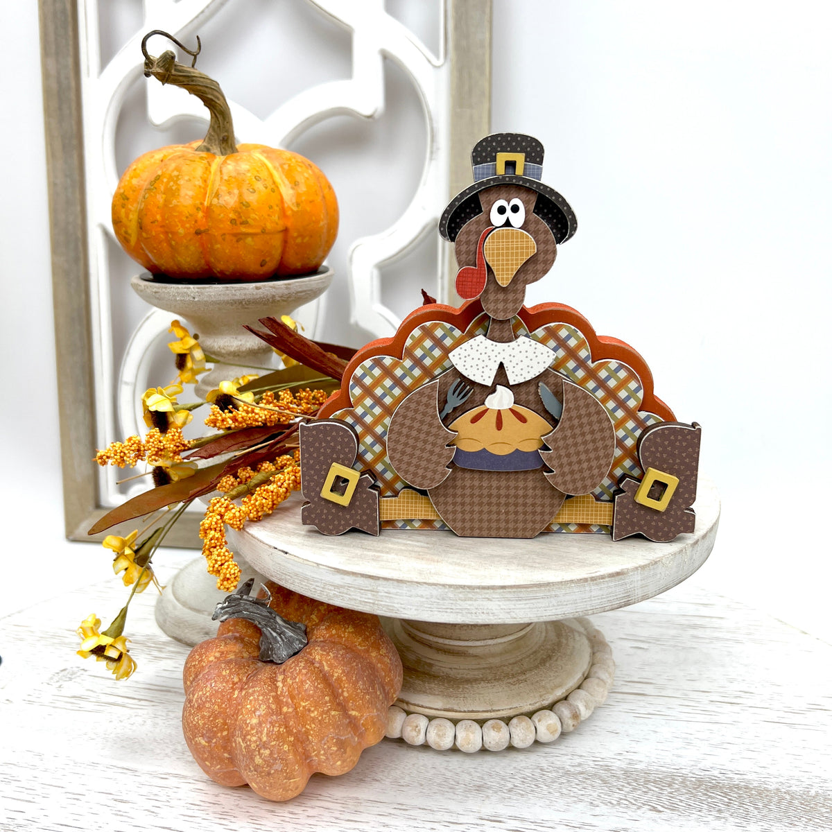 Sitting turkey eating pie decoration on a white pedestal stand
