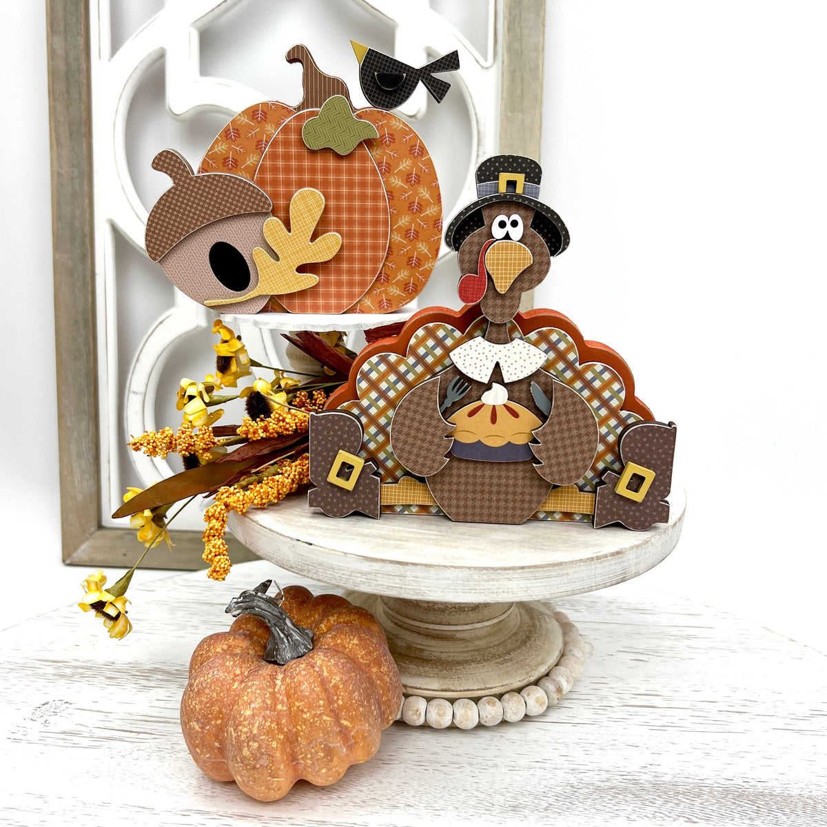 Sitting turkey eating pie and fall pumpkin decoration on a white pedestal stand