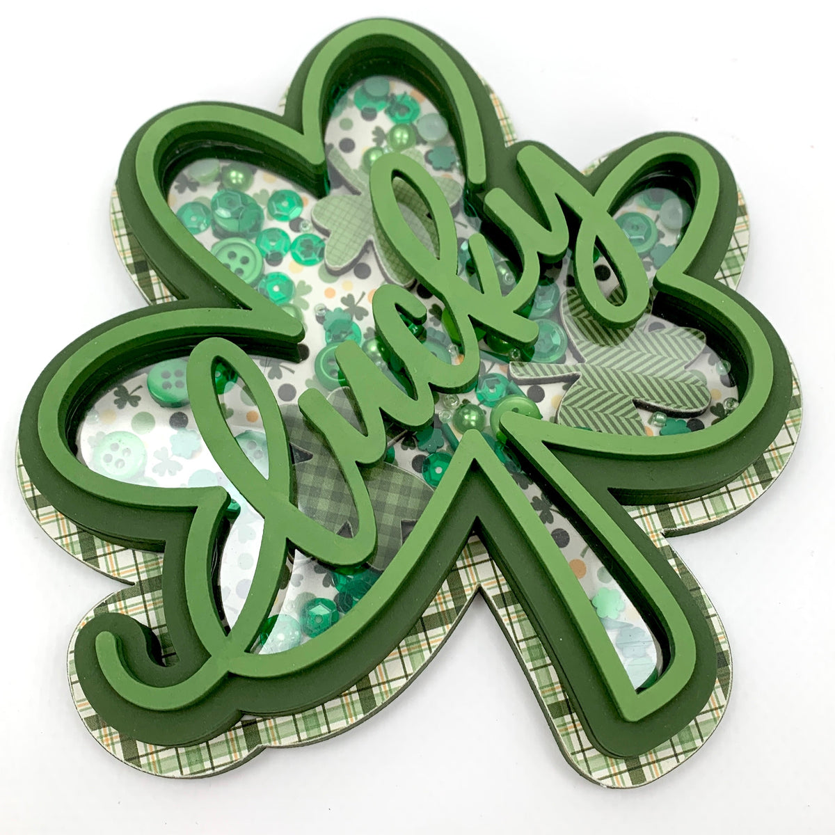 Green wood shamrock with the word lucky filled with confetti and sequins.