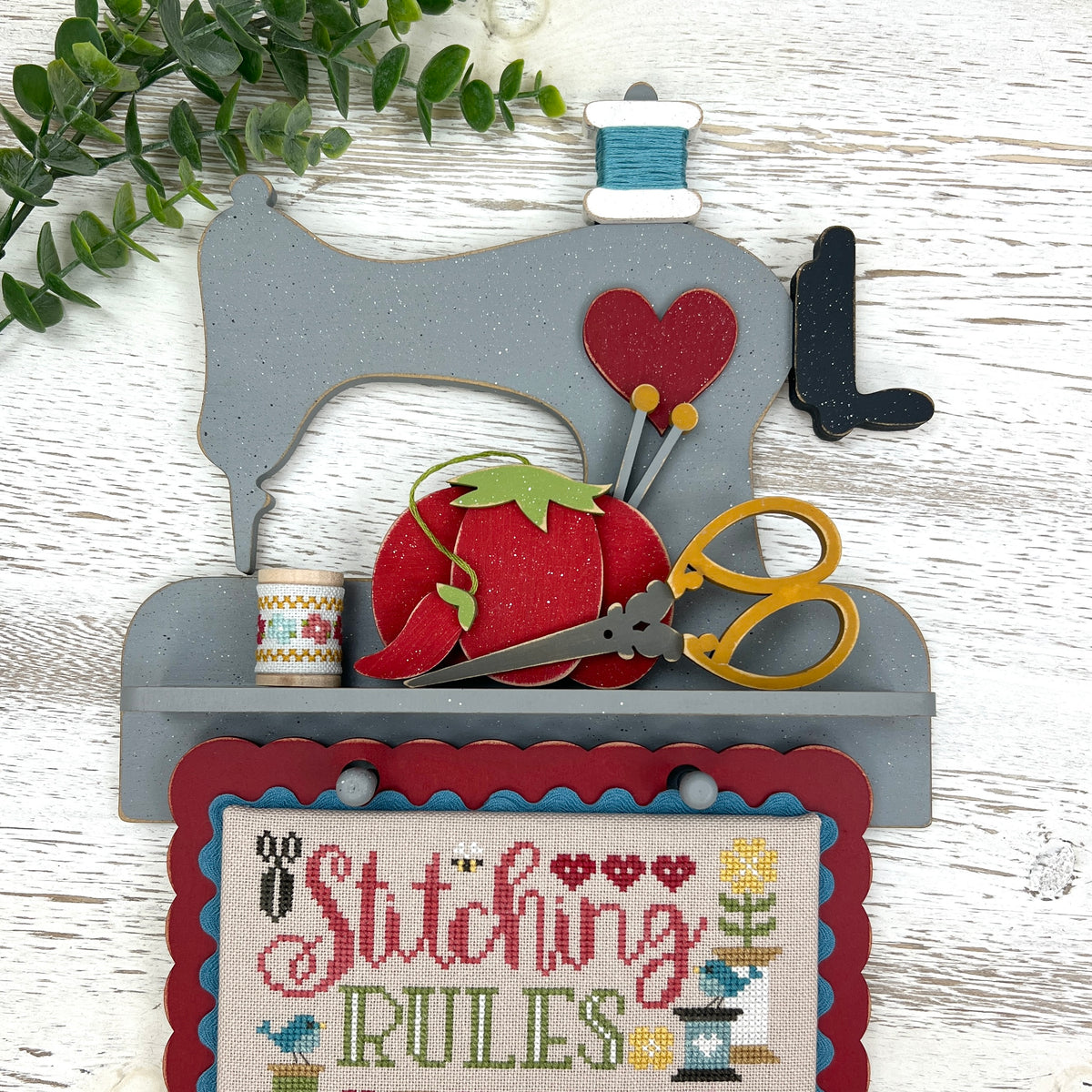 DIY sewing machine cross stitch display decorated with tiny sewing shapes and Stitching Rules finish