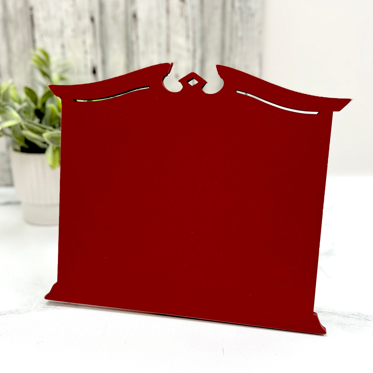Pre painted red Traditional Cross Stitch Display with a classic shaped top, decorative cutout details, and lightly distressed edges.