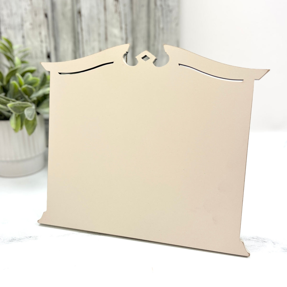 Pre painted cream Traditional Cross Stitch Display with a classic shaped top, decorative cutout details, and lightly distressed edges.