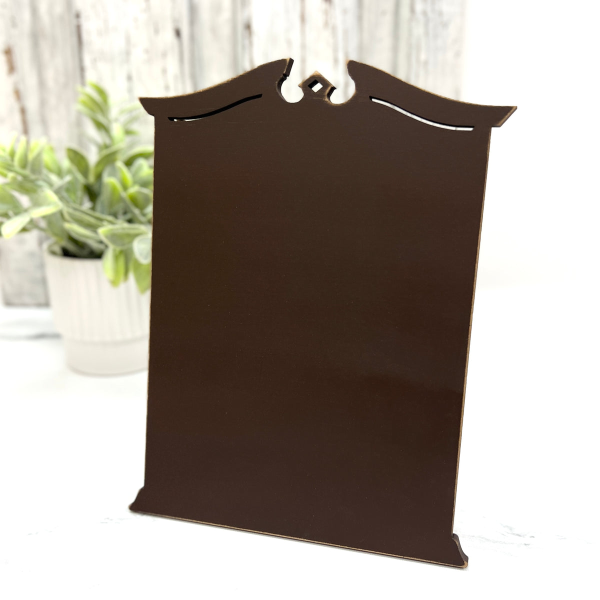 Pre painted brown tall Traditional Cross Stitch Display with a classic shaped top, decorative cutout details, and lightly distressed edges.