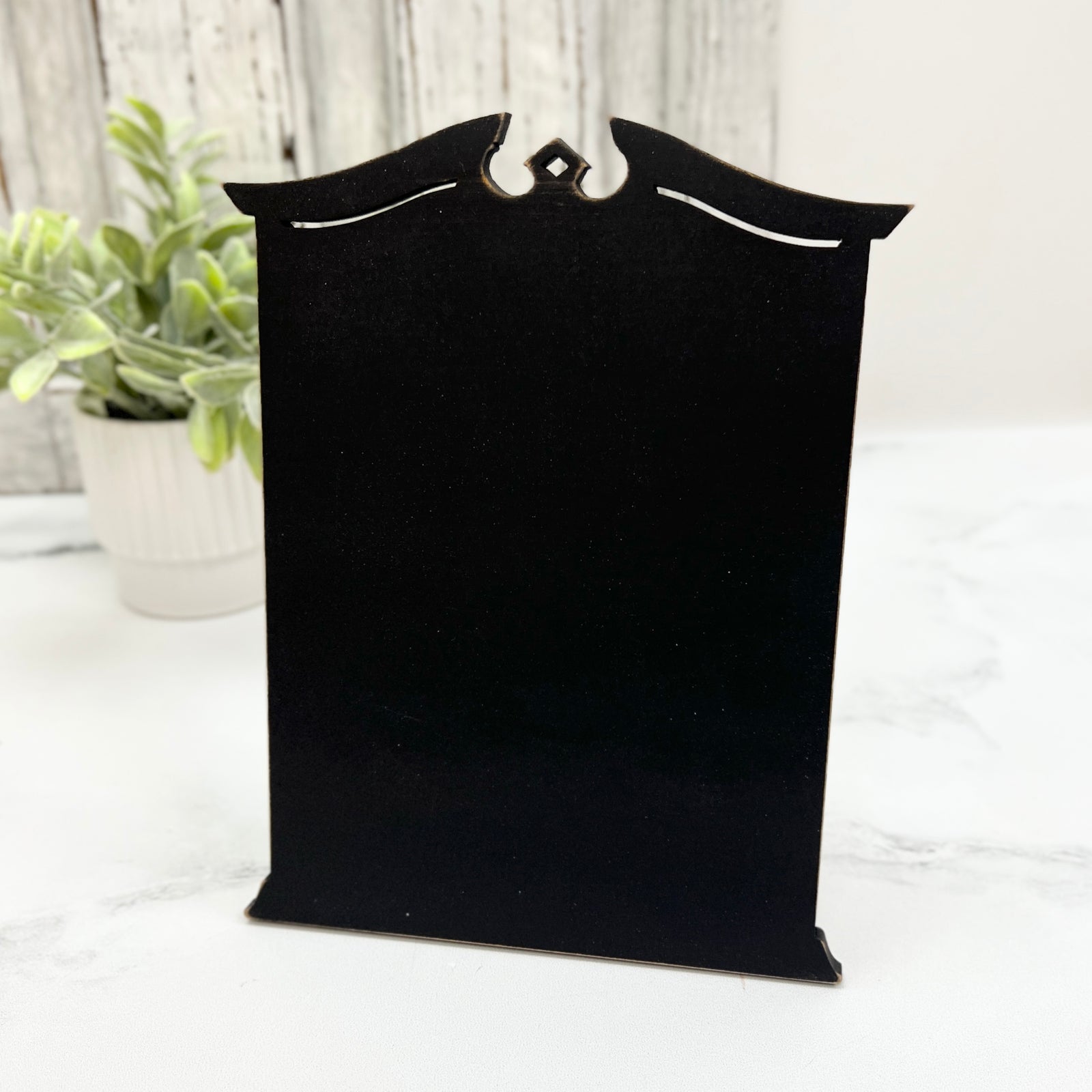 Pre painted black Traditional Cross Stitch Display with a classic shaped top, decorative cutout details, and lightly distressed edges.
