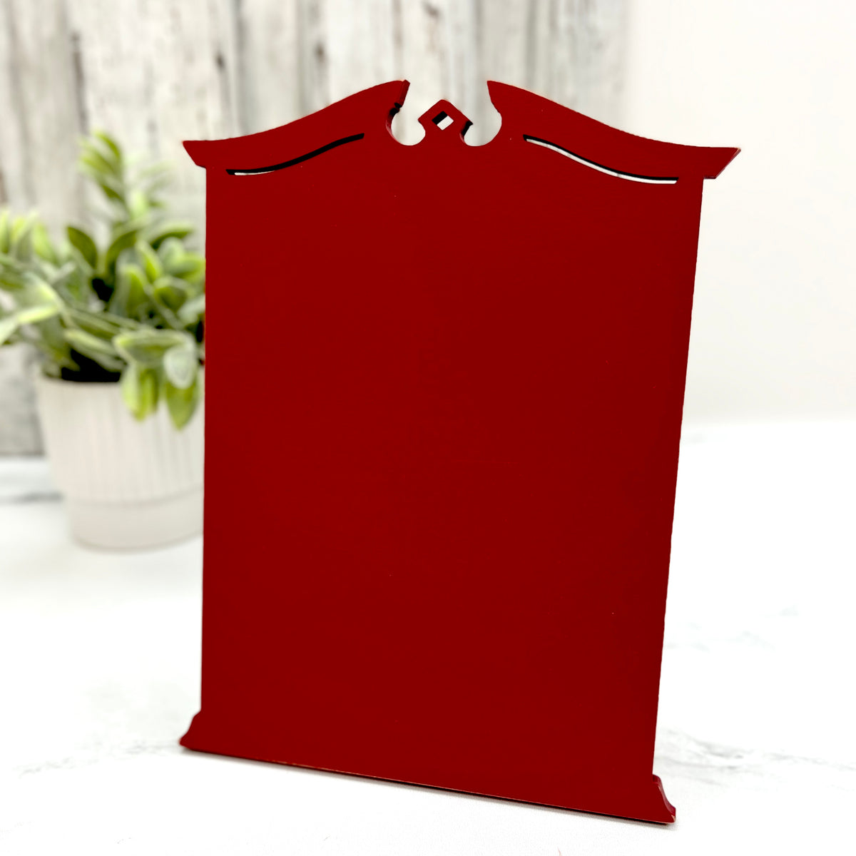 Pre painted Red Tall Traditional Cross Stitch Display with a classic shaped top, decorative cutout details, and lightly distressed edges.