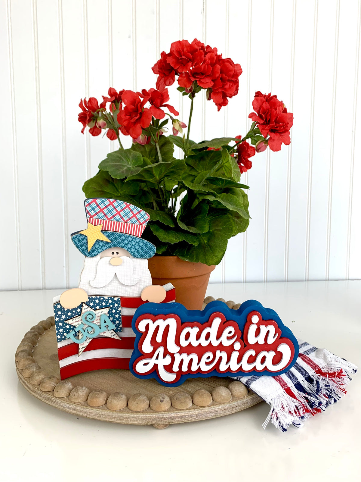 Made in America 4th of July sign with an Uncle Sam holding a flag on a wood tray